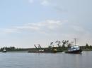ICW Traffic: Tug fore and aft towing a barge and very long pipe.